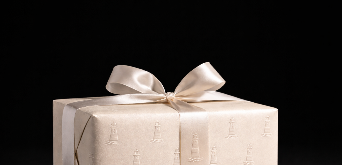 Beige gift box with a ribbon on a black background
